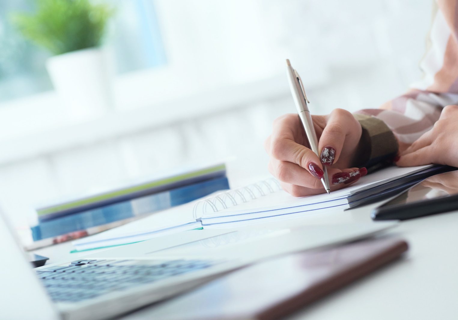 Businesswoman makes thoughts records at personal organizer, white collar conference.